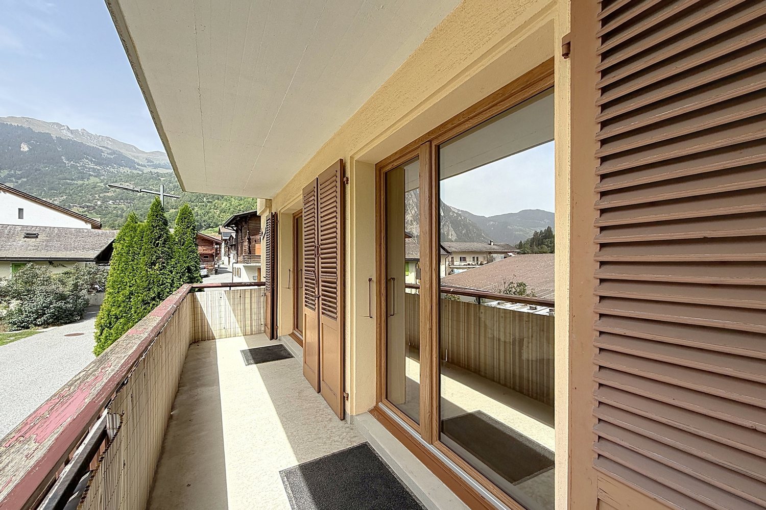 Balcon couvert du premier étage, volets bois et vue sur les toits de Montagnier et les montagnes.